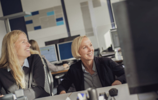Zwei Frauen sitzen vor dem Computer