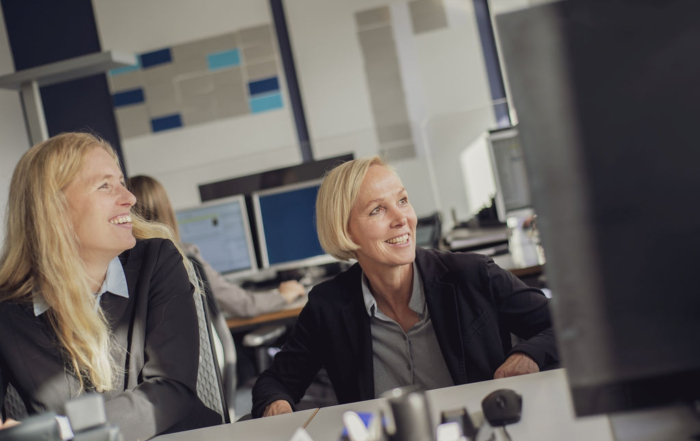 Zwei Frauen sitzen vor dem Computer